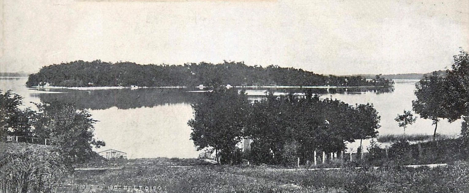 Old postcard view of Coney Island, a long wooded island, seen across Lake Waconia from the Waconia shore