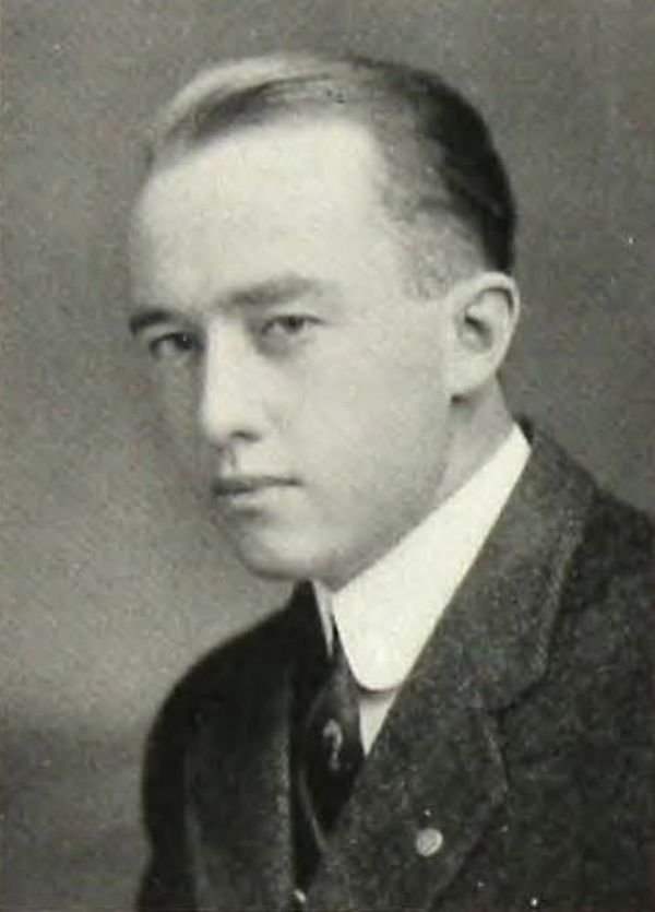 Black and white yearbook portrait of a young Chester W. Johnson in a dark suit, white collar, and tie