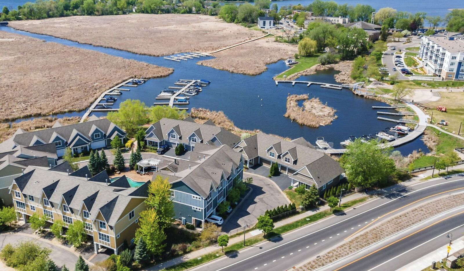 Aerial view of The Villas on Lost Lake townhomes, the marina slips, and the dredged channel running out to Cooks Bay on Lake Minnetonka in Mound, Minnesota