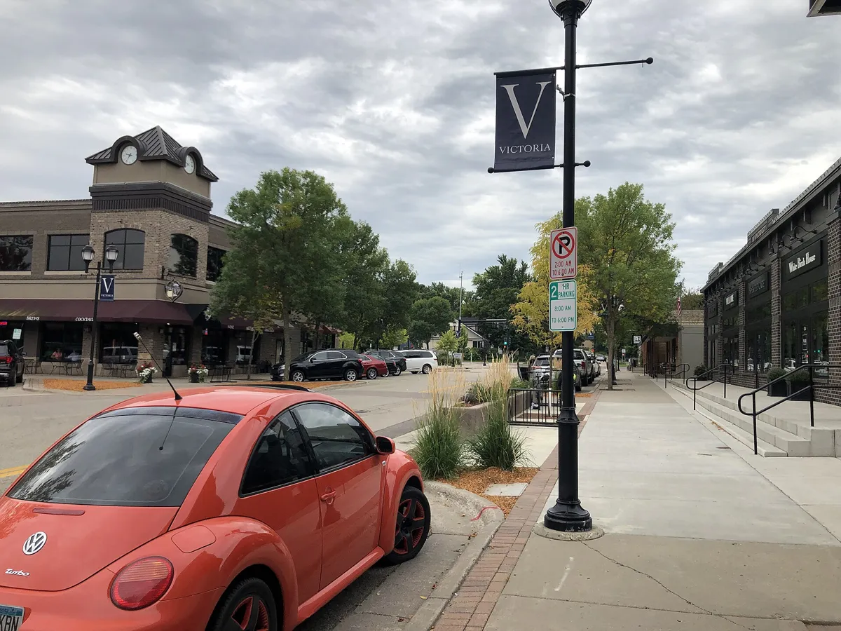 Downtown Victoria, Minnesota, with brick storefronts, a clock tower and a V street banner
