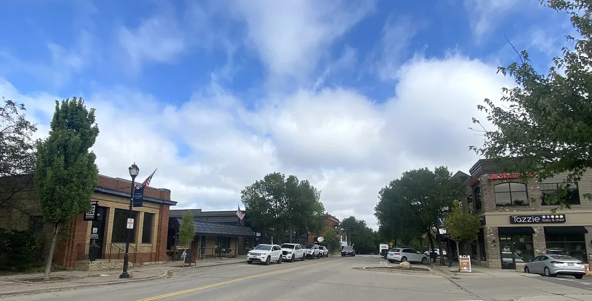 Storefronts and lamp posts along Victoria Drive under a blue sky